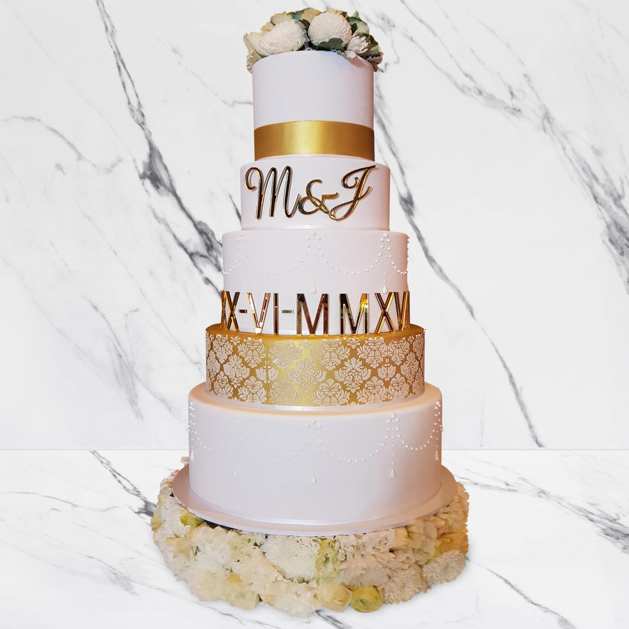 Fondant covered wedding cake – 5 tier gold shimmer with floral base